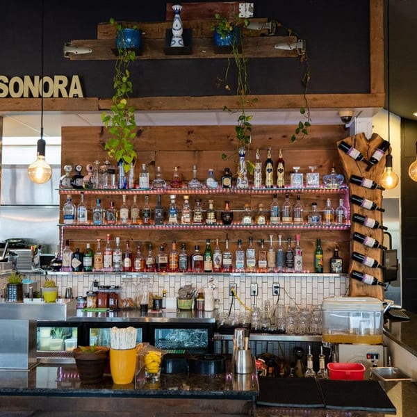 A well-stocked bar at Sonora Grill, featuring numerous tequila bottles, wine, and bar equipment.