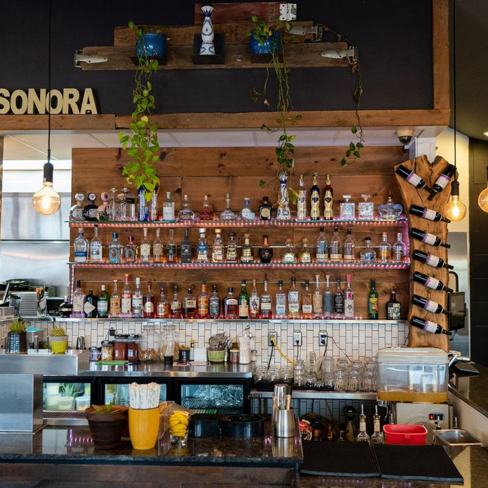 A well-stocked bar at Sonora Grill, featuring numerous tequila bottles, wine, and bar equipment.
