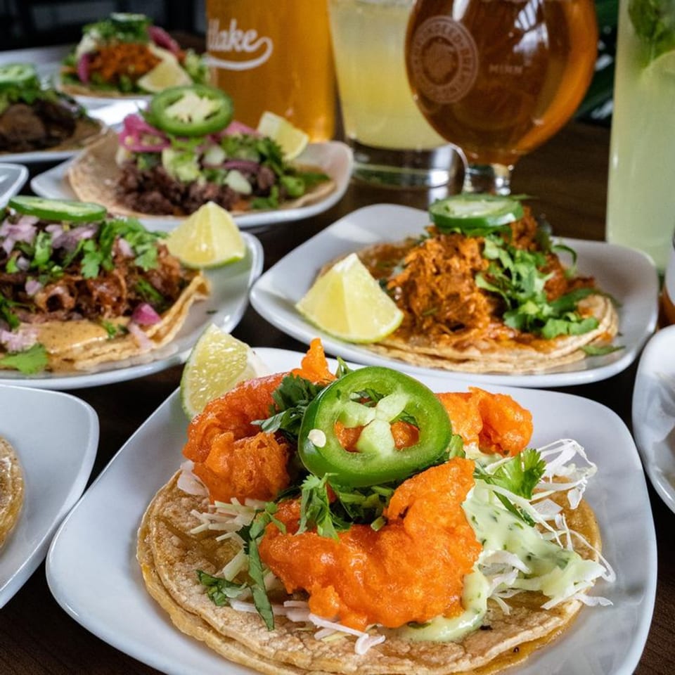 A close-up of Sonora Grill's Mexican tacos, featuring various fillings, fresh toppings, and lime wedges.