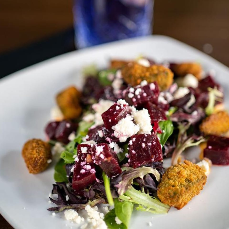 Beet salad with crumbled feta cheese, mixed greens, and crispy fried goat cheese balls.