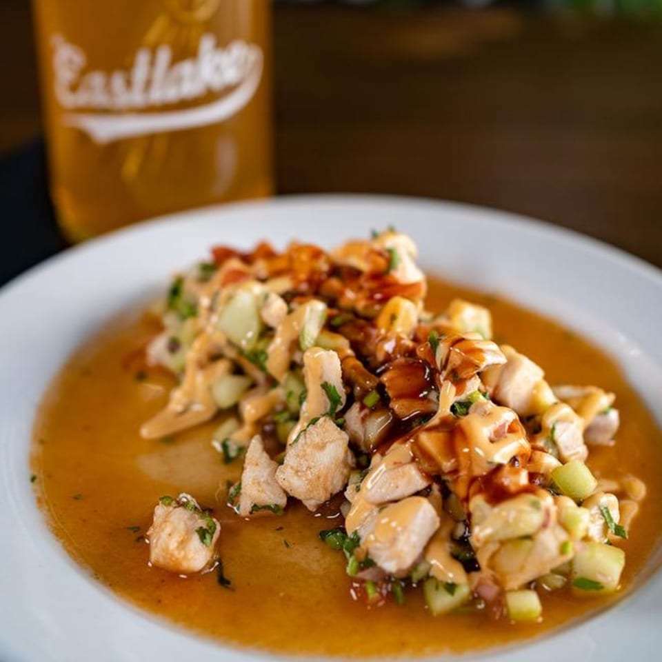 Sonora Grill's Mexican ceviche with chicken, cucumber, and sauce, next to a glass of Eastlake beer.